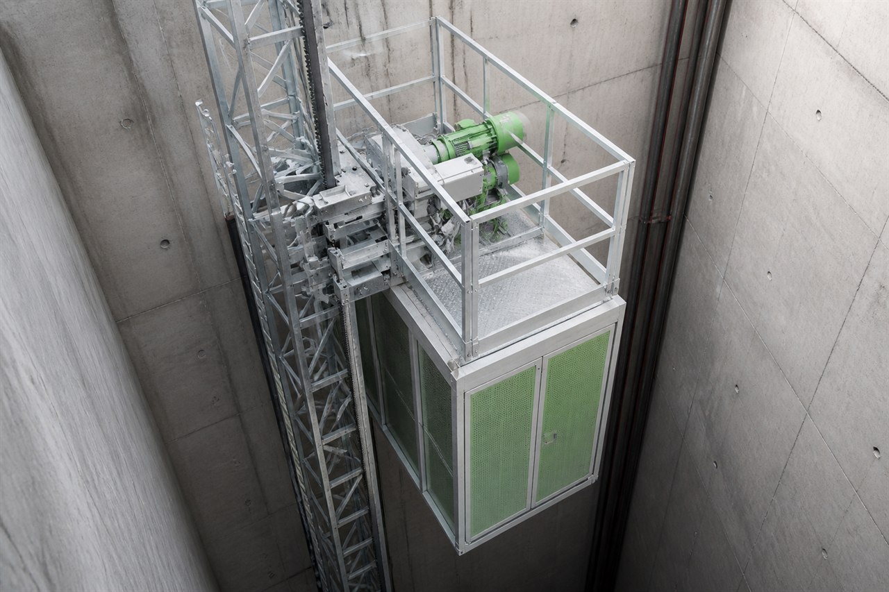 Compact slipform hoist installed within a concrete construction shaft